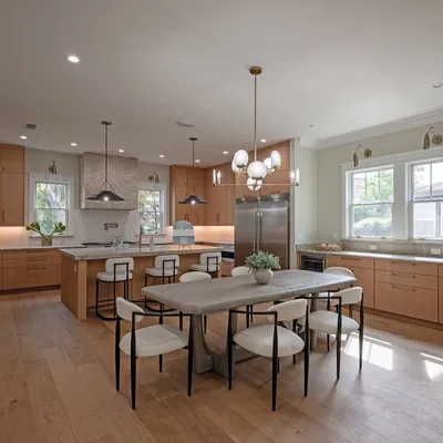 Dining area open to the kitchen under designer pendant lighting