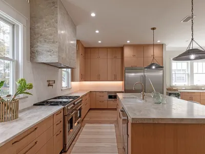 Chef's kitchen with oversized island, wood cabinetry, and gas range