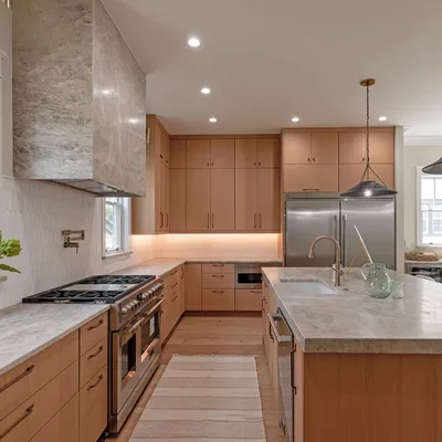 Chef's kitchen with oversized island, wood cabinetry, and gas range