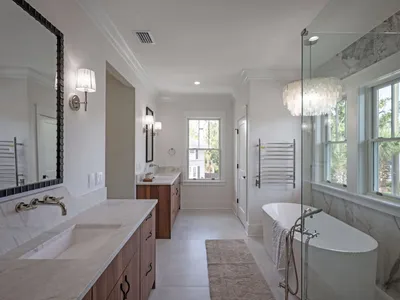 Primary spa bath with soaking tub, chandelier, and double vanities