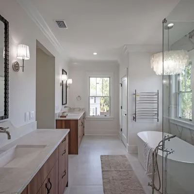 Primary spa bath with soaking tub, chandelier, and double vanities